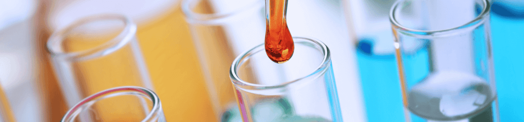 A pipette with red liquid hovers above a row of clear test tubes, some filled with pale blue liquid, set against a blurred multicolored background, epitomizing precision and innovation in lab services.