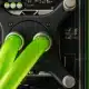 Close-up view of a computers liquid cooling system with two bright green tubes connected to a black component, surrounded by circuit board elements and heatsinks.